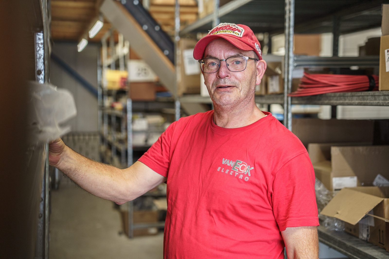 Magazijnbeheerder Gerrit tussen de stellingen in het magazijn